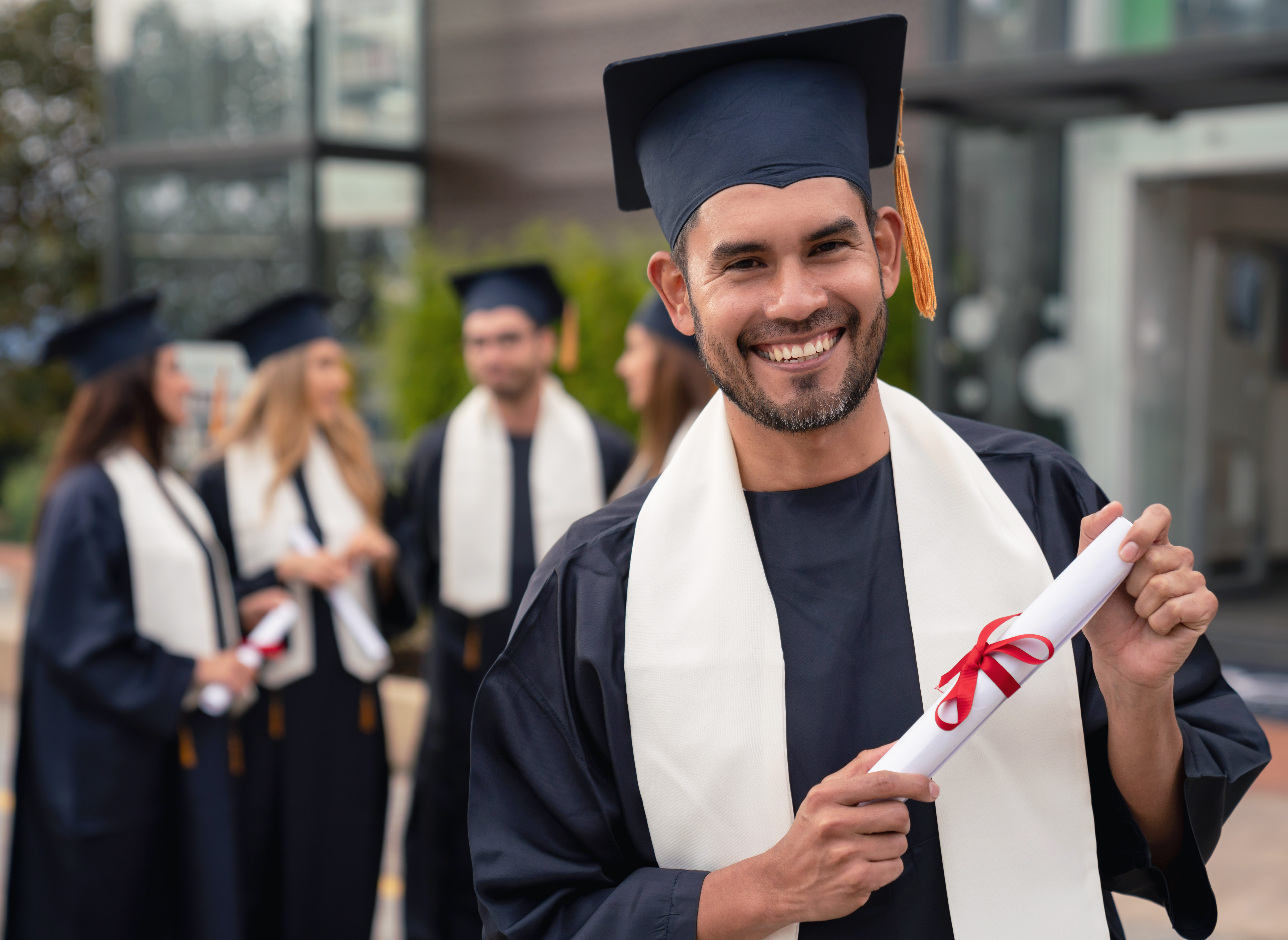 Young man graduating holding a diploma